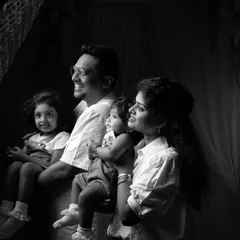 A candid black and white shot of a family looking off-camera, capturing a natural and unposed moment together.