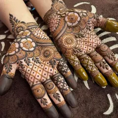 This design features a beautiful mix of jaali (net) patterns on the fingers and bold floral mandalas on the palm. The dark-tipped fingers are a traditional touch that many of my brides love.