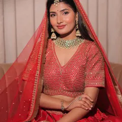 A close-up of this gorgeous red designer lehenga. Notice the delicate sequin work on the blouse and the rich gold embroidery on the skirt. It’s all about timeless elegance.