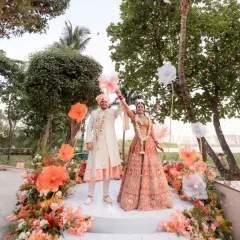The moment of celebration. The couple stands on a beautifully decorated stage as guests shower them with petals, marking the conclusion of their ceremony.