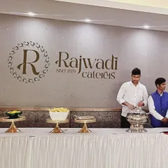 My staff at a serving station with our "Rajwadi Caterers, Since 1979" branding clearly visible on the wall. This reinforces my long-standing experience in the catering industry.
