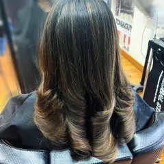This client's long hair was cut with soft, blended layers and styled with an inward curl for a polished finish. This technique helps to add shape and reduce bulk in thick hair.