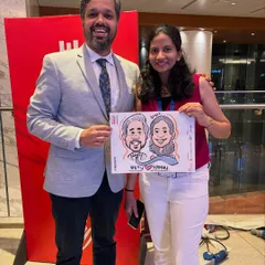 A couple poses with their caricature at a corporate gathering. It's a great ice-breaker and adds a fun, personal touch to professional events.