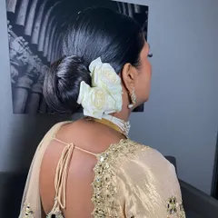 Another angle of this sleek bridal bun, showing how the white roses are carefully placed to create a beautiful side profile. This style works wonderfully with traditional attire and veils.