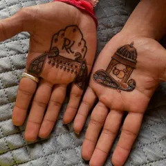 A close-up of the groom's hands, showing the two distinct yet coordinated designs. The patterns are minimal but meaningful.