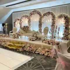 This reception stage is all about sophisticated glamour, featuring a series of grand floral arches in soft pink and white. The elevated platform, classic seating, and cascading flowers create a luxurious and picture-perfect setting for the newlyweds.