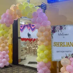 The entrance to the first birthday party, featuring a colorful pastel balloon arch and a personalized welcome sign for the little one, setting a festive mood right from the start.