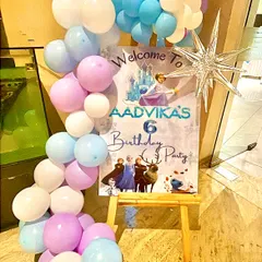 A closer look at the personalized welcome sign for Aadvika's 6th birthday party, framed by a beautiful cascade of 'Frozen' themed balloons.