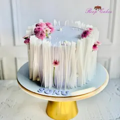A trendy and modern design using wafer paper to create a beautiful, textured effect. The lavender cake is adorned with fresh purple flowers for a touch of natural elegance.