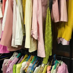 The clothing rack is my canvas. Here's a glimpse of the curated selection for a shoot, with a palette of pinks, yellows, and greens ready to be mixed and matched to create different looks.