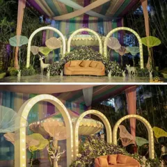 A whimsical, forest-themed stage decoration. The setup features illuminated arches, large mushroom-like props, and statues of deer and rabbits, creating a magical and enchanting fairytale setting.