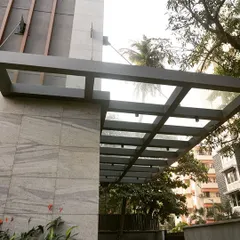 We designed a sleek glass and metal canopy at the building's entrance to protect the car lift doors from the weather while complementing the modern façade design.