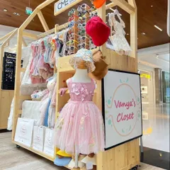 Another view of a custom wooden kiosk for a kids' fashion brand, 'Vanya's Closet'. The mobile design includes clothing racks and a prominent space for branding, making it a versatile solution for mall exhibitions.