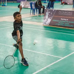 A young shuttler shows intense focus during the PSM Open Junior Badminton Tournament. These events are designed to build competitive experience and mental toughness from a young age.