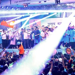 The main stage is illuminated with powerful spotlights, highlighting the dignitaries and the massive crowd at the Dahihandi Utsav. Our lighting design ensures key moments are visible to everyone.