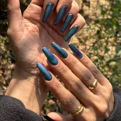 This peacock nail set is pure magic. Using a special cat-eye polish, the colors shift from deep blue to vibrant green depending on the light. It's a long-lasting gel extension look that guarantees compliments.
