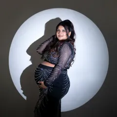 In the spotlight. This dramatic lighting technique creates a bold, iconic portrait that celebrates the mother-to-be as the star of the show.