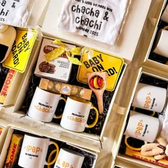 A bird's-eye view of a bulk order for a family-wide pregnancy announcement. Each box is carefully curated with personalized mugs, onesies, and goodies to celebrate the upcoming arrival.