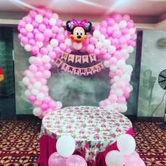 For a child's birthday, I can create themed decorations like this Minnie Mouse setup. It includes a large balloon arch shaped like mouse ears and a matching table cover for the cake cutting ceremony.