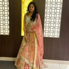 A client looking radiant in our mint green and peach designer lehenga. This shows how our rental outfits look for a real event, offering a high-end designer look for your special occasion.