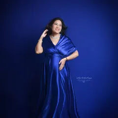A full-length shot showcasing the elegance of this satin maternity gown. The way the fabric drapes beautifully highlights the baby bump.