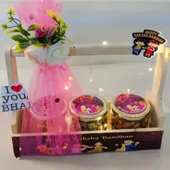 A classic Rakhi hamper in a wooden basket, featuring three jars with custom Raksha Bandhan labels, all wrapped in festive pink tulle.