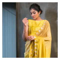 A graceful lime and ivory half saree, paired with a blouse featuring exquisite self-thread work. This ensemble offers a subtle and sophisticated take on traditional wear.