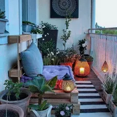 An inspirational image showing a cozy balcony setup with pallet furniture, lanterns, and an abundance of potted plants, demonstrating how to create a bohemian-style retreat in a small space.
