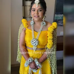 For this bride's Haldi ceremony, I created a full set of fresh flower jewellery and a matching floral dupatta, also known as a 'shela'. The bright yellow marigolds and contrasting white flowers create a look that is both traditional and vibrant.