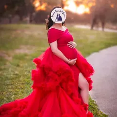 This bold red ruffled gown with a high slit is a popular choice for a glamorous outdoor shoot. The vibrant color and dramatic design create unforgettable pregnancy portraits.