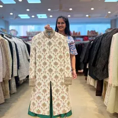 Here is a beautiful ivory sherwani with detailed block-print style embroidery, paired with a contrasting green inner kurta. It’s a sophisticated option for a groom looking for traditional elegance.