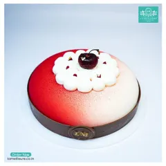 This is my Black Forest Revisited cake. It features a modern design with a red and white velvet spray finish, a chocolate collar, and a single fresh cherry on top of delicate cream piping.