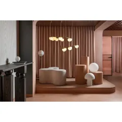 We created distinct zones using raised platforms and heavy drapes. This area showcases a collection of modern globe pendants and a sculptural bench, demonstrating how different lighting styles can define a space.