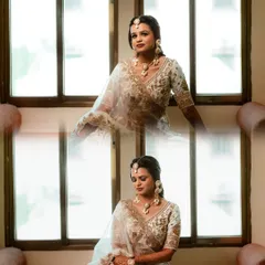 A beautiful portrait of the bride by the window, her white and gold lehenga looking ethereal in the natural light.