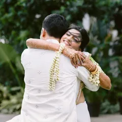 A beautiful, windswept hug. This is the moment of reunion after a long-distance separation, a first look filled with emotion, relief, and overwhelming love.