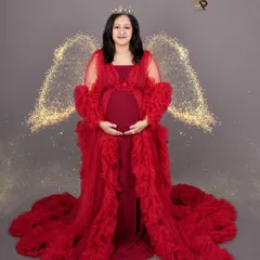 A truly angelic portrait. We combined a magnificent red ruffled gown from our collection with sparkling angel wings and a crown to create this powerful and ethereal image for our mom-to-be.