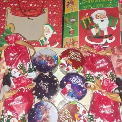 Getting into the holiday spirit with these Secret Santa gifts. This collection includes Christmas-themed tins filled with chocolates and festive gift bags, ready to spread some cheer.