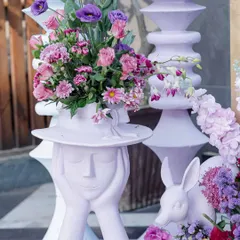 Whimsical sculptures, like this lady with a floral hat, added a unique and artistic touch to the Victorian garden theme.