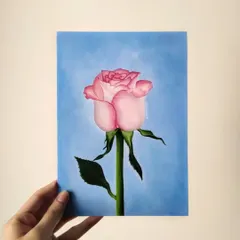 A hand-held view of my oil painting of a pink rose. This piece is an example of the still life and botanical art I can create for you.