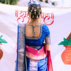 The back of the bridal look is just as important as the front. Here, you can see the beautifully adorned bridal bun and the perfect drape of the Paithani saree, creating a stunning silhouette.