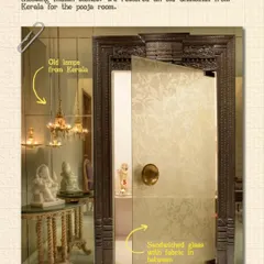 For this pooja room, we restored an old Chaukhat (doorframe) from Kerala and paired it with traditional lamps. The door itself features fabric sandwiched between glass, a modern technique that respectfully frames the heritage element.