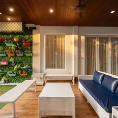 This balcony was designed to feel open and fresh. A vertical garden wall with colorful planters adds energy and life, while the white wicker furniture and wooden deck keep the space feeling warm and simple.