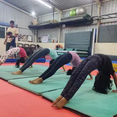 The bridge, or back arch, is a fundamental exercise for improving spinal flexibility and shoulder strength. Here, a group of students practices their bridges in unison on soft mats.