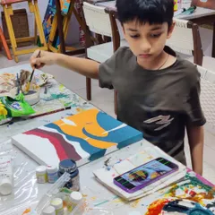 A young artist at our acrylic workshop, carefully adding colors to his abstract piece. The camp is a great place to try new mediums.
