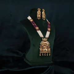 A side-angle view of the traditional necklace set on a bust, highlighting the depth and dimension of the pendant and beadwork.