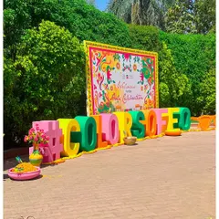 A large, 3D "#COLORSOFEO" sign served as the primary branding and photo-op for this corporate Holi event. The colorful letters and floral details created a fun, shareable moment.
