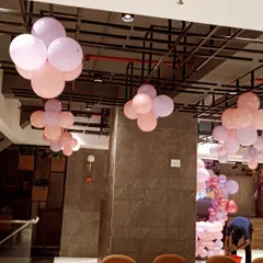 Ceiling decorations can transform a space. Here, I've used simple balloon bunches in pastel colors to add a festive feel to the entire venue.
