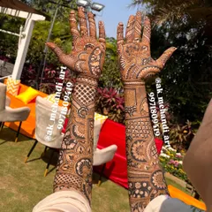 This full bridal mehndi was done for a destination wedding, with the beautiful outdoor decor in the background. The design features a mix of geometric grids and traditional Indian motifs.