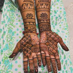 This full bridal design combines a variety of patterns, including jaali (net), floral bands, and traditional elephant motifs near the elbows, creating a rich and textured look.