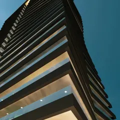A detail shot looking up at the Embrace Tower's facade. The rhythmic pattern of the balconies and the clean, straight lines of the interior structure create a powerful architectural statement.